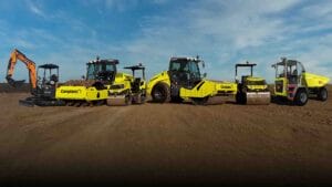 Five yellow construction vehicles showcase our 2026 Fleet Strategy on a dirt lot under blue skies.