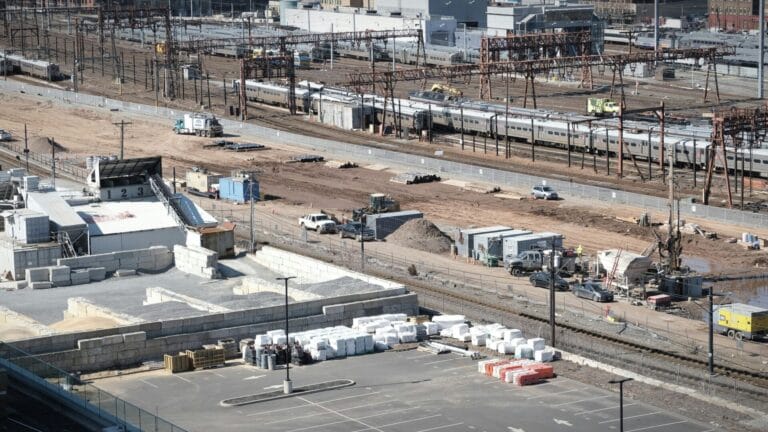 A construction site by train tracks showing 2026 infrastructure pipeline and equipment.